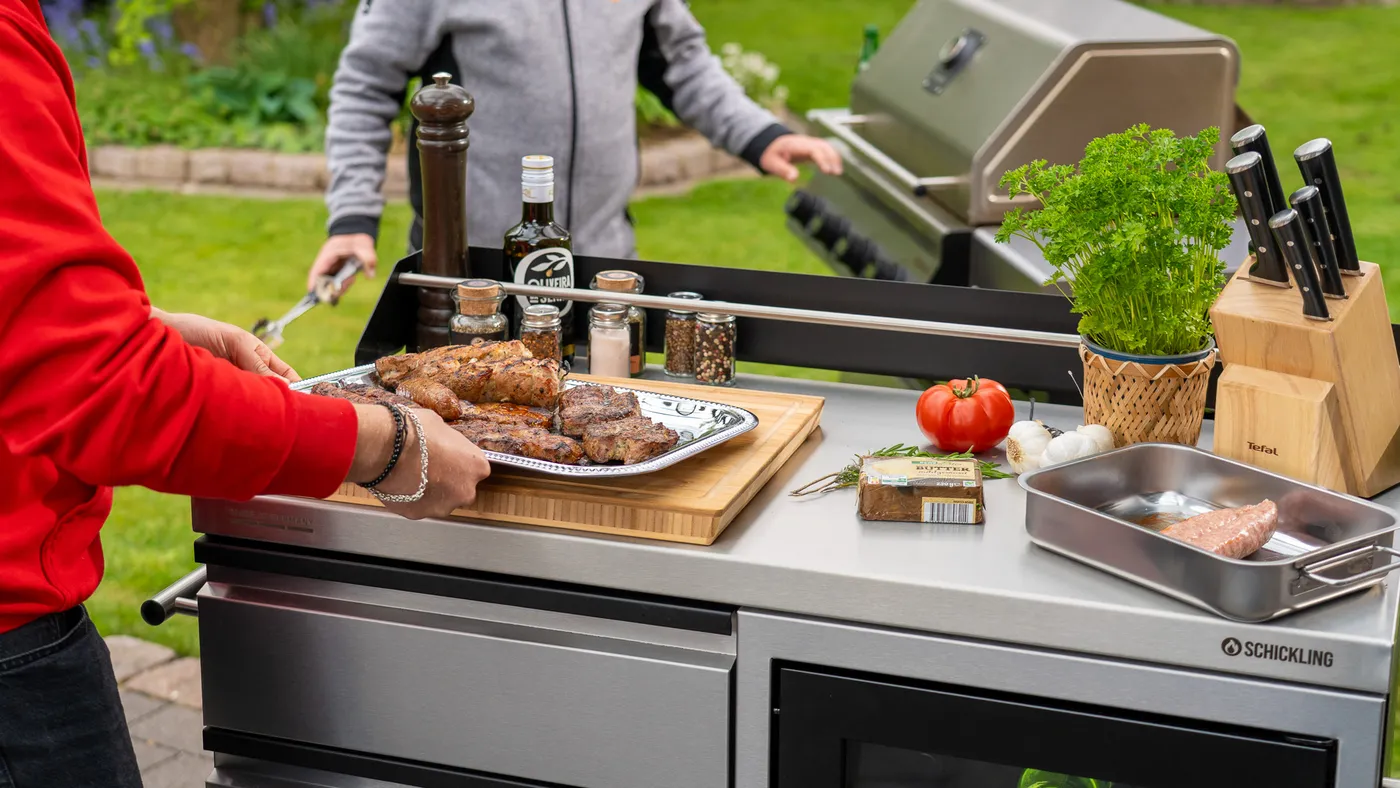 Buddy-Grilltisch mit Grillgut und Gewürzen neben dem Grill